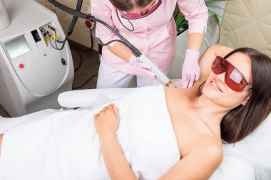 Koltuk altı lazer epilasyon profesyonel kozmetik kliniğinde olan güzel bir kadın. Profesyonel ekipman