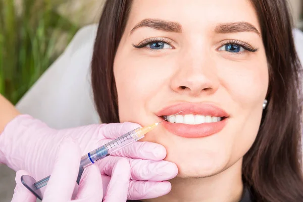 Happy patient girl in a comet clinic. Procedure for lip correction with fillers. Professional cosmetology service — Stock Photo, Image