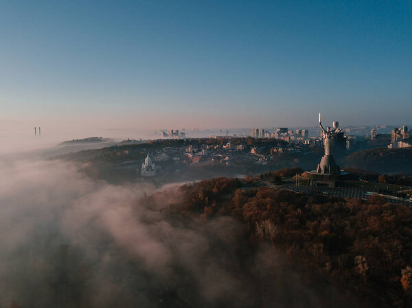 Памятник Родине. Киевская столица популярных туристических мест для посещения. Фото беспилотника Эриэля сверху. Туманное осеннее утро в Киеве
