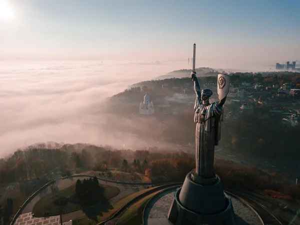 Kiev Ucrania los lugares turísticos más populares para visitar el Monumento a la Patria. Foto aérea de dron de enorme estatua de acero de la mujer con escudo y espada. Niebla fría hermosa mañana de otoño —  Fotos de Stock