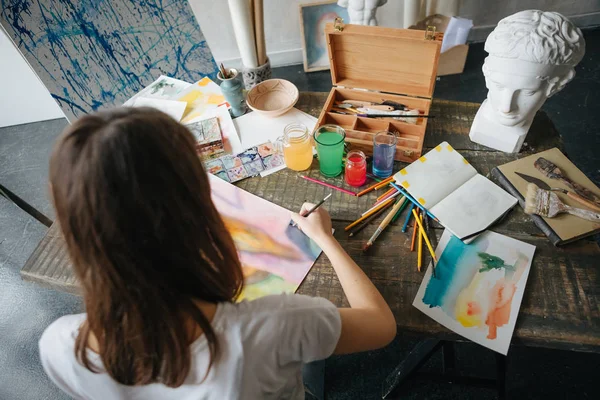 Artista pintor jovem menina bonita. Processo de criação de trabalho. pintura em cavalete. trabalho inspirado. Composição horizontal. Vista superior de cima para a mesa de trabalho . — Fotografia de Stock