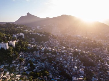 Rio de Janeiro Brezilya gün batımı. Havadan fotoğraf evlere tepeler ve dağlar. Güzel gün batımı arka ışık. Favela akşamları