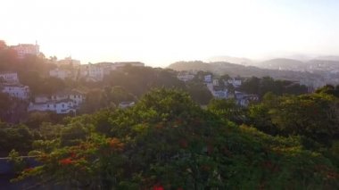 Rio de Janeiro şehir havadan görünümü video görüntüleri. Favelas tepeler. Gün batımı arka ışık. Yukarıdan.