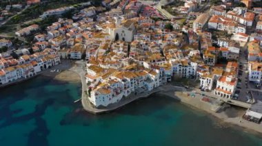 Cadaques İspanya. Hava video. Drone kiremitli çatıları, dar sokakları, beyaz evler ve bir kilise üzerinde uçan. Güzel mavi deniz