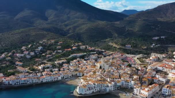 Cadaques: Ισπανία. άνετα και όμορφα σπίτια, δρόμους και κεραμιδένιες στέγες. Εναέριο κηφήνα πλάνα βίντεο της κάμερας προσεγγίσεις της πόλης. ηλιόλουστο φως της ημέρας. Βουνά και την πόλη — Αρχείο Βίντεο