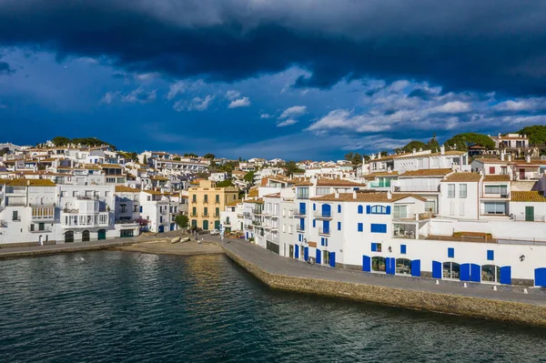 Cadaques tourist Holiday destination in Spain. Streets with white houses. walking mood. Sunny day with dark blue cloudy sky