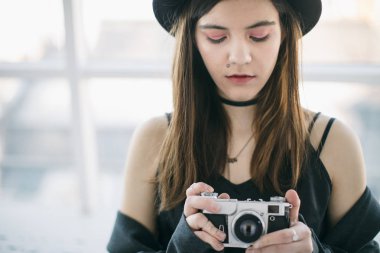 dikkatle kamera ile çalışıyor. Güzel genç fotoğrafçı kız. İnanılmaz yaratıcı iş eğitimi