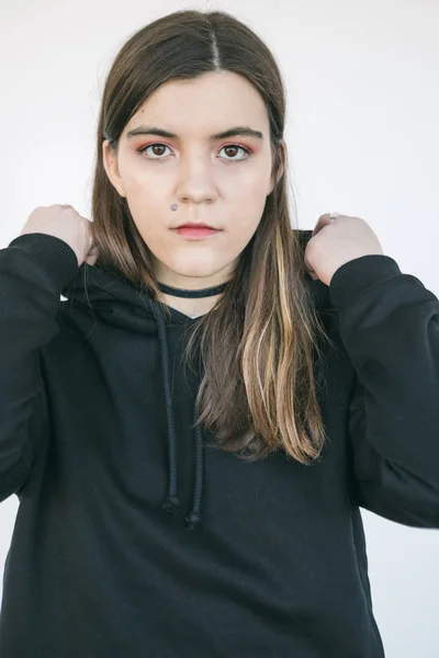 Porträtt av ung vacker flicka i svart hoodie. Whie bakgrund. Naturligt mjukt dagsljus — Stockfoto
