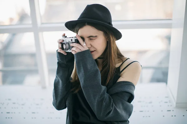 Fotografi hobby. Snygg ypung fotograf flicka i svart hatt. Mjukt bakgrundsljus — Stockfoto