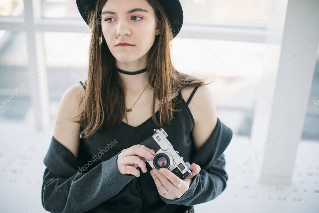 Beautiful girl photographer in stylish hipster clothes
