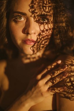 dantel ve gölgeler. Genç bir kadının şehvetli seksi portre. Güzel uzun saçlar. Dramatik psikolojik portre