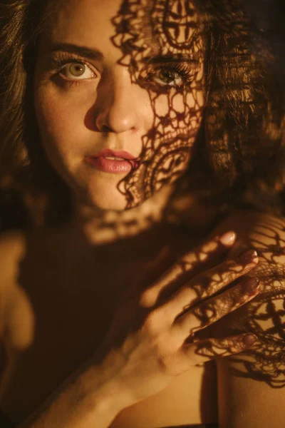 dantel ve gölgeler. Genç bir kadının şehvetli seksi portre. Güzel uzun saçlar. Dramatik psikolojik portre