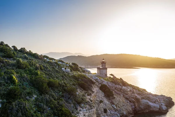 Poros udara Yunani Dana lighthouse.Romantic Sunset cahaya latar belakang. Kepulauan Yunani di latar belakang. Foto cahaya emas ajaib. Tampilan drone udara . — Stok Foto