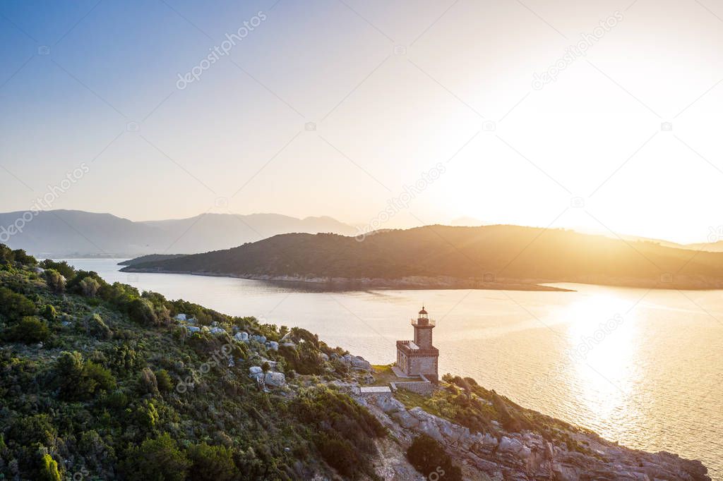 Aerial Poros Greece Dana lighthouse. Sunset backlight. Greek islands on background. Magic golden light photo. Aerial drone photo