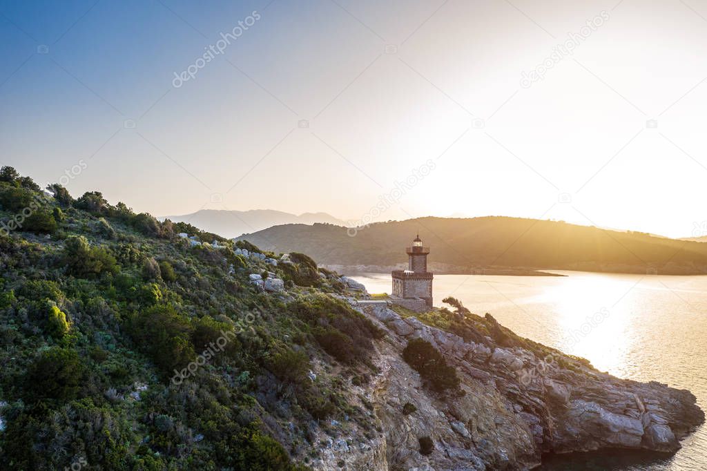 Aerial Poros Greece Dana lighthouse.Romantic Sunset backlight. Greek islands on background. Magic golden light photo. Aerial drone view.