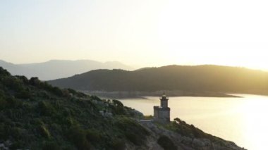 Hava Poros Yunanistan Dana deniz feneri. Romantik Sunset arka ışık. Arka planda Yunan adaları. Sihirli altın ışık. Havadan insansız hava aracı görünümü. Video görüntüleri
