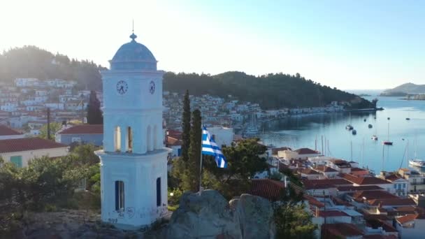 Isla de Poros Grecia. Iglesia en la colina. Desarrollando románticamente la bandera nacional. Imágenes aéreas — Vídeo de stock