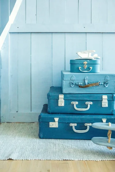 Niebieskie walizki na podłodze w pokoju dziecięcym. Dekoracyjne przechowywanie rzeczy. — Zdjęcie stockowe