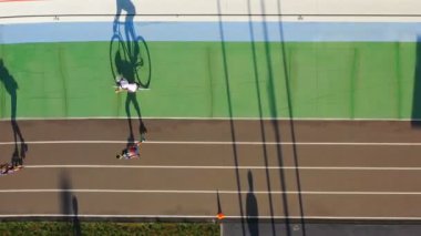 Spor tema ilham. velodrome bisikletçi ve Paten eğitimi. Havadan video görüntüleri. Uzun gölgeler akşam ışığı