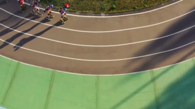 Spor eğitimi. Rollerdrome'da patenciler. Havadan video görüntüleri. Daire şekli. Uzun gölgeler