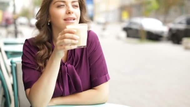Pausa para el café capuchino. Café de la calle. Hermosa mujer en vestido púrpura. Imágenes de vídeo — Vídeos de Stock