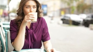 cappuccino ve kahve kafe ziyaretçi kahve içeceği olan güzel genç kadın. Video görüntüleri. Yaz sokak kafe