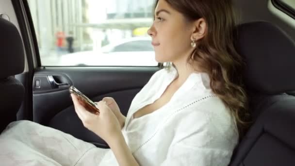 Улыбающаяся Счастливая Женщина Белом Платье Заднем Сидении Автомобиля Помощью Мобильного — стоковое видео