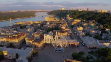 Ukrayna 'da Kyiv' de (Kiev) güzel bir yaz akşamı günbatımı günbatımından yukarıdan gelen panoramik hava aracı görüntüsü. Podil bölgesi Posta Meydanı Dönme dolabı ve Sahaidachnoho Caddesi Avrupa 'nın başkenti