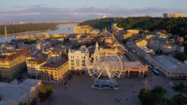 Ukrayna 'da Kyiv' de (Kiev) güzel bir yaz akşamı günbatımı günbatımından yukarıdan gelen panoramik hava aracı görüntüsü. Podil bölgesi Posta Meydanı Dönme dolabı ve Sahaidachnoho Caddesi. Avrupa 'nın başkenti