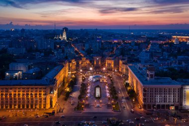 Kyiv (Kiev) Ukrayna Meydanı Meydanı (Independence Square) akşam aydınlatma fıskiyeleri ve mimarisi. Turist eğlencesi devrim yerini ziyaret etmeli. Yukarıdan hava aracı fotoğrafı