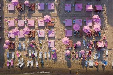 Pembe şezlonglu plaj manzaralı şezlong. Yukarıdan gelen orijinal hava aracı sanatsal kompozisyonu. Üst görünüm olağandışı bakış. Yaz tatili tatil havasında. Rahatlamanın tadını çıkar.. 