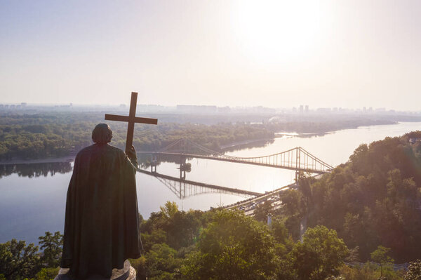 Kyiv Ukraine. Monument to St. Volodymyr of Kiev view to Dnipro river Parkovy Pedestrian and Bicycle Bridge. cross symbol christianity orthodox. blesses the city at dawn. panoramic beautiful historic 
