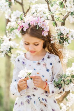 Bahar bahçesindeki güzel bir kızın portresi. Saçında çiçekler.