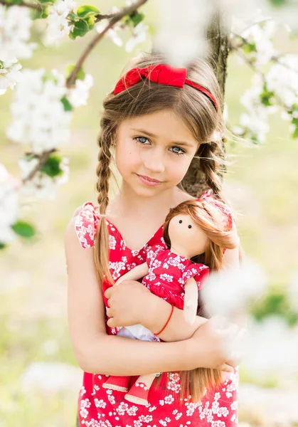 Aranyos Lány Egy Piros Sundress Egy Baba Tavaszi Kertben — Stock Fotó