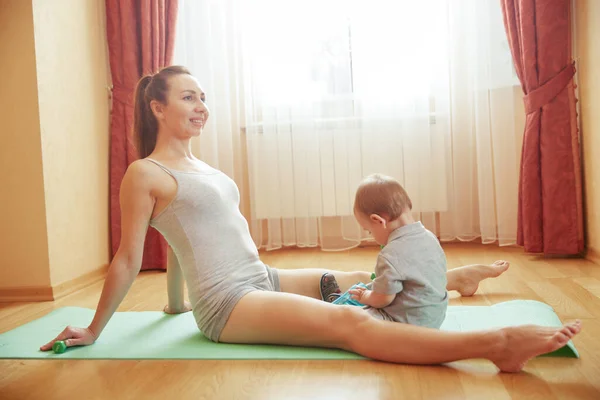 Mother rest with baby after gymnastics exercises — Stock Photo, Image