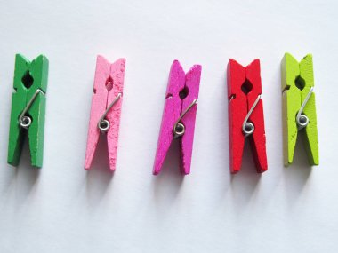 Işık arka planda üç renkli clothespins