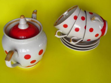 Sarı bir arka plan üzerinde çay için bezelye seramik yemekleri. Su ısıtıcısı, bardak, tabak.