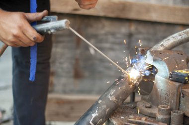 Metalin elektrik kaynağı. Egzoz borusu, metal nesnelerle çalışma.