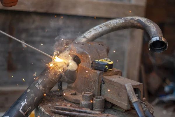 Electric welding of metal. Exhaust pipe, work with metal objects.