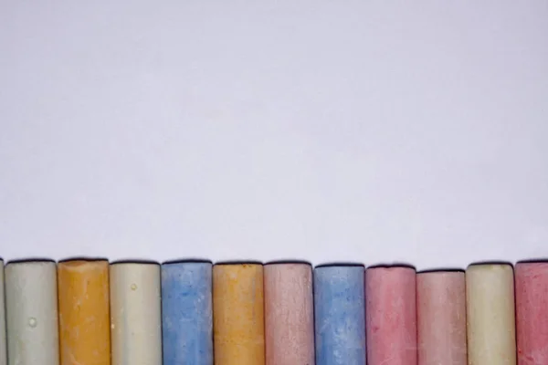 Fila di colore misto di gesso usato pastello bastoni pastello isolato su sfondo bianco. Concentrazione selettiva morbida. Spazio di copia testo . — Foto Stock