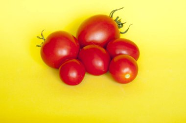 Sarı bir arka plan üzerinde taze kırmızı domates