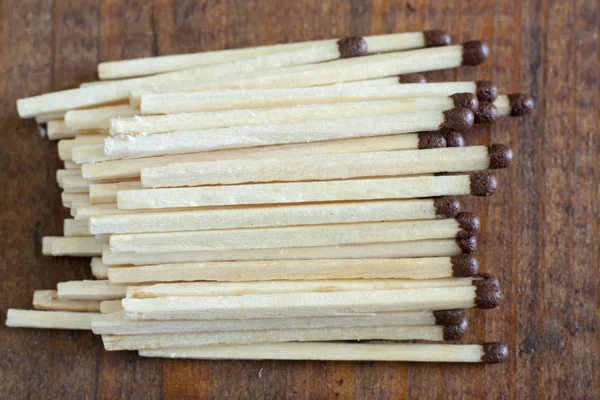 Wooden matches scattered on a wooden table — Stock Photo, Image