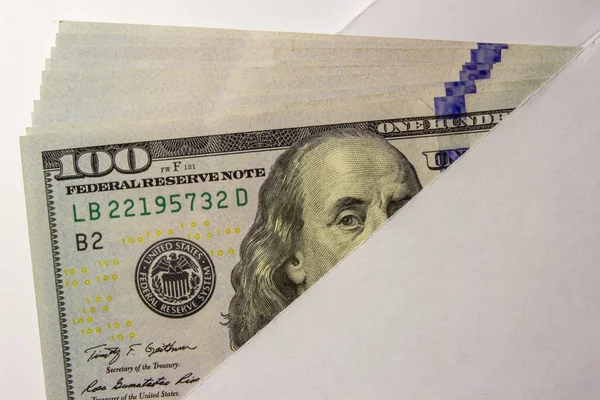 100 rachunki dolara, pieniądze leżące w białej kopercie na białym tle. BRIBE dla urzędnika. — Zdjęcie stockowe