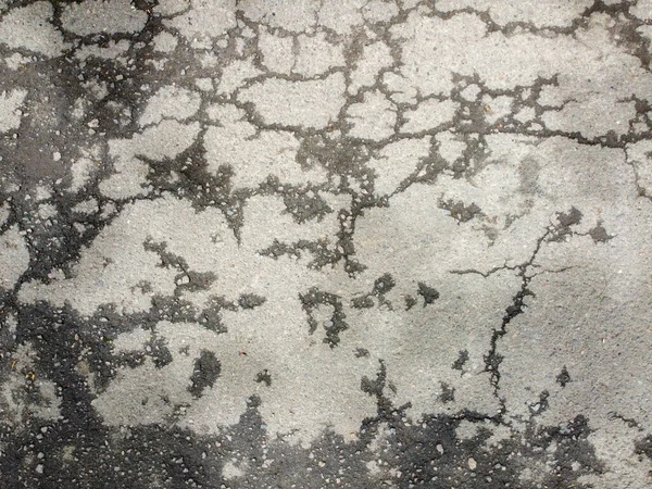 在沥青路面上有裂缝 剥皮后有部分湿透的沥青路面 裂缝路面的结构 — 图库照片