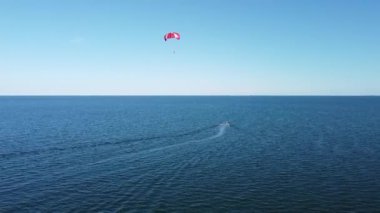 Sahildeki tatil köyünde inanılmaz bir eğlence, tekneyle paraşüt, mavi deniz, denizde tatil..