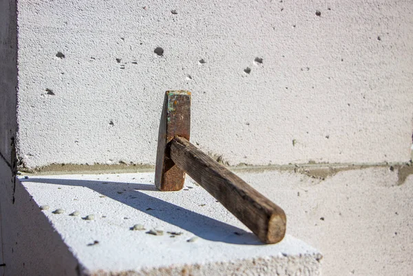 An old hammer on a white foam concrete block from which to build a house from which the shadow falls — Stock Image Old Hammer White Foam Concrete Block Which Build House Which Royalty Free Stock Images