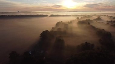 Sabah güneşi, vadiden yayılan sislerin arasından köydeki ağaçların arasından süzülüyor..