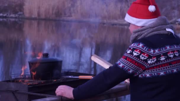 Chapéu de Papai Noel em um churrasco. Churrasqueira exterior na praia com um chapéu de Santa . — Vídeo de Stock