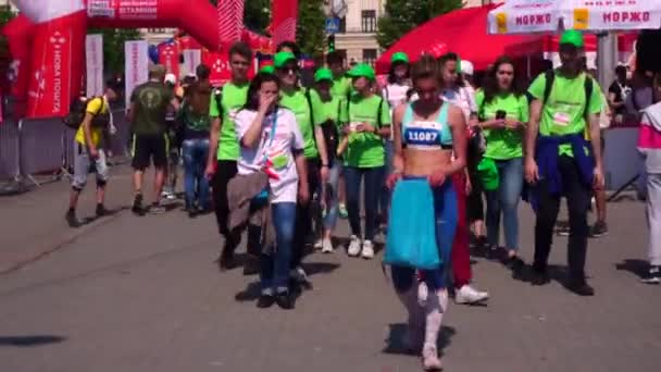 ZAPORIZHZHIA, UCRÂNIA - 27 de abril de 2019: Pessoas, participantes e organizadores da maratona em Zaporozhye. Depois da corrida, estão cansados. A pista para corredores, o organizador do "Novo Correio" barracas . — Vídeo de Stock