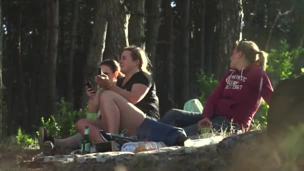 Tre belle, giovani ragazze sedute sul copriletto, a terra in jeans, felpa, pantaloncini, costume, scarpe da ginnastica, scarpe da ginnastica, sandali, occhiali da sole, fumare una sigaretta elettronica per ore e bere — Video Stock